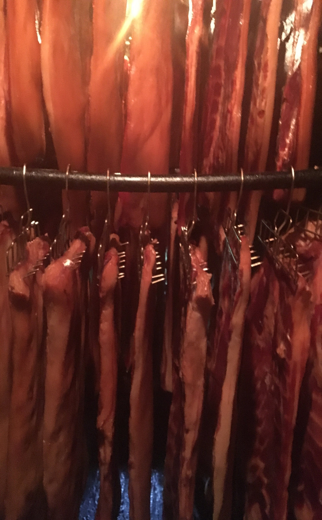 HICKORY BACON HANGING IN SMOKEHOUSE